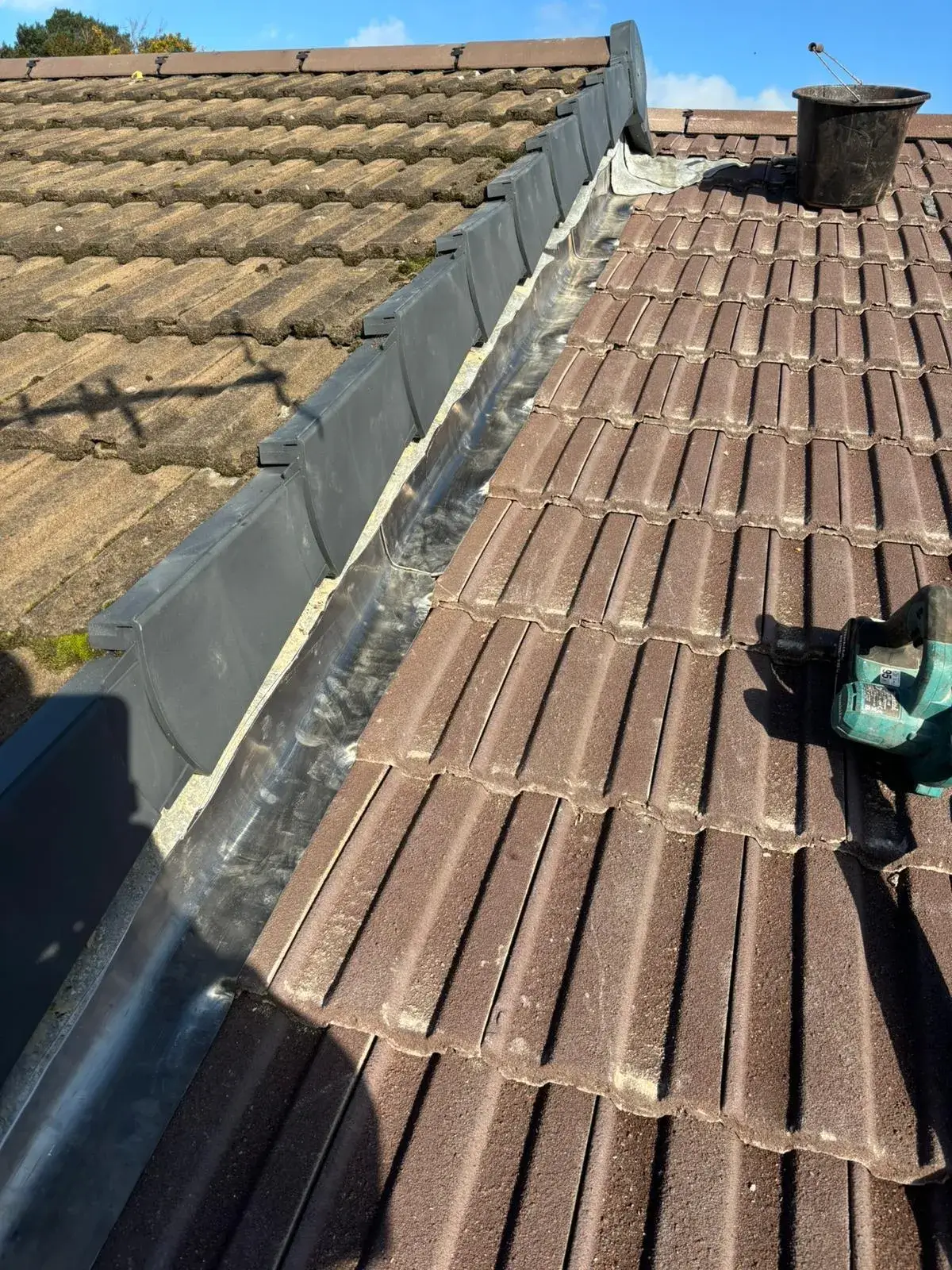 The roof of a house with a broken gutter.